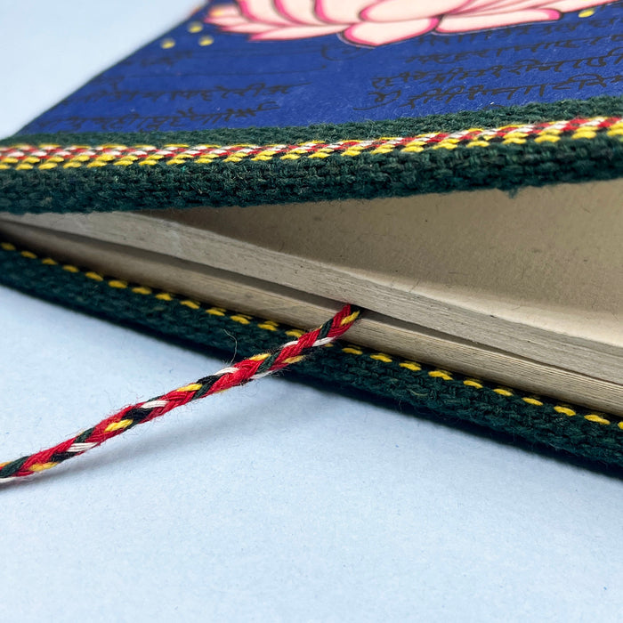 A handmade cotton paper diary with a printed lotus design cover, adorned with goddess Laxmi design in vibrant colors