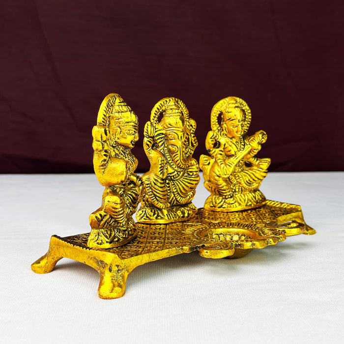 Metal Laxmi Ganesha Saraswati Idols with Diya on Leaf Chowki