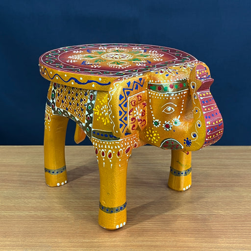 A Handmade Embossed Painted Wooden Elephant Stool on a Table